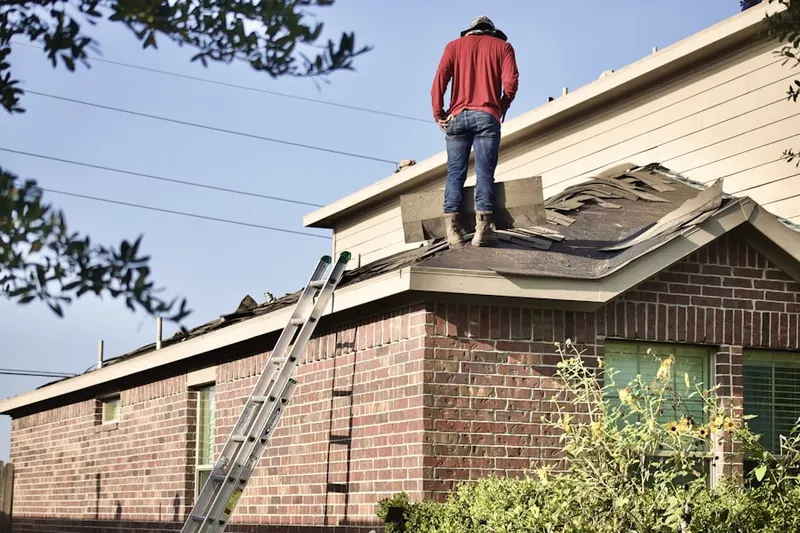 Professional roofer working on a residential roof in Medina